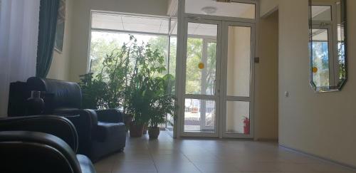 a waiting room with a glass door and a plant at Altyn-Adam Hotel in Astana