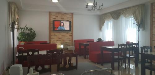 a dining room with red chairs and a table at Altyn-Adam Hotel in Astana