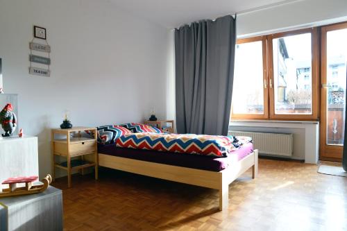 ein Schlafzimmer mit einem Bett und einem Fenster in der Unterkunft Hindenburg str Apartments in Garmisch-Partenkirchen