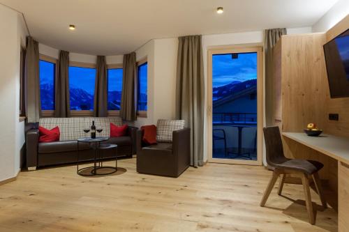 a living room with a couch and a table at Apart-Hotel Dreisonnenhof in Fiss