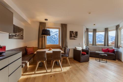 a kitchen and living room with a table and chairs at Apart-Hotel Dreisonnenhof in Fiss