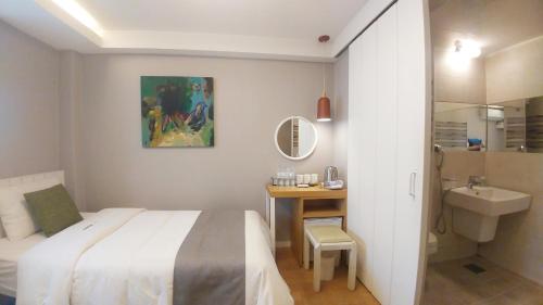 a bedroom with a bed and a bathroom with a sink at Hotel QB Dongdaemun Gallery in Seoul