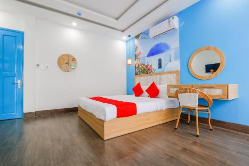 1 dormitorio con 1 cama con espejo y silla en Santorini House and Coffee en Da Nang