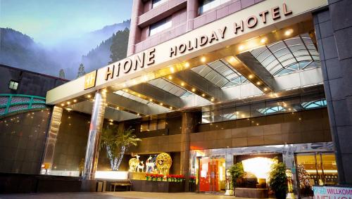 a hotel with a sign on the front of it at HiONE Holiday Hotel in Shenkeng