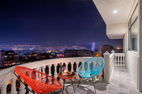 a balcony with two chairs and a view of the city at Vera Hills Boutique Hotel in Tbilisi City