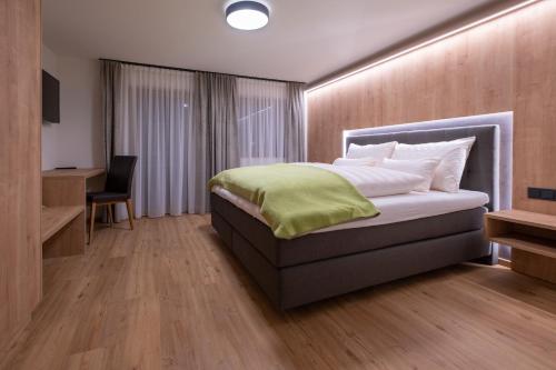 a bedroom with a bed and a desk and a chair at Apartment Haus Schönwies in Alpbach