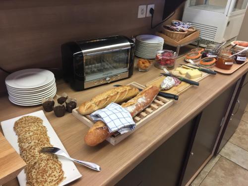 um balcão com pão e pastelaria e um micro-ondas em Les Étoiles Du Forez em Montbrison