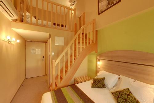 1 dormitorio con 1 cama y escalera en Les Étoiles Du Forez en Montbrison