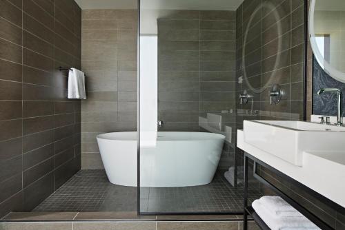a bathroom with a tub and a sink at Kimpton Sawyer Hotel by IHG in Sacramento