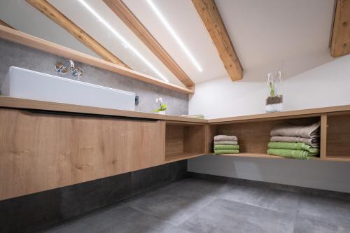 a bathroom with a sink and wooden cabinets at Apartment Haus Schönwies in Alpbach