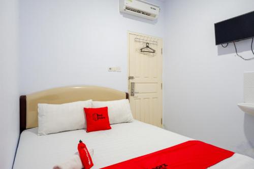 A bed or beds in a room at RedDoorz @ Hotel Bravo Pantai Kamali Bau Bau