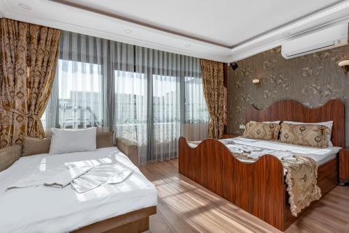 a bedroom with two beds and a large window at OASIS SUITES OLD CITY in Istanbul