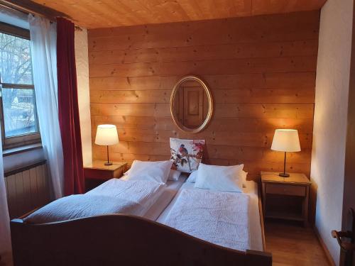 a bedroom with two beds with a mirror and two lamps at Appartement Pension Bäckenhäusl FERIENWOHNUNGEN Chalets Hütten Komfortzimmer in Uttendorf