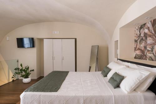 a bedroom with a large white bed with a painting on the wall at Le Pennellate Short Lets in Catania