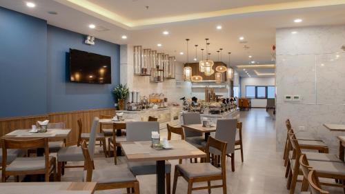 a restaurant with tables and chairs and a bar at Seana Hotel in Nha Trang