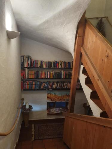 a staircase with a book shelf with books at Appartement Pension Bäckenhäusl FERIENWOHNUNGEN Chalets Hütten Komfortzimmer in Uttendorf