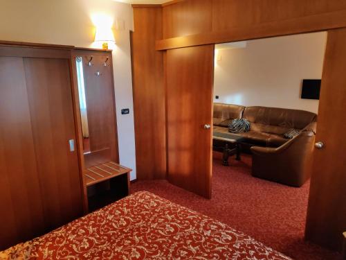 a living room with a couch and a door with a mirror at Hotel Amalia in Ludbreg