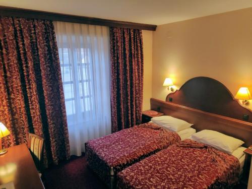 a hotel room with a bed and a window at Hotel Amalia in Ludbreg