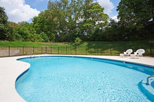 a large swimming pool with two chairs at Candlewood Suites Knoxville Airport-Alcoa by IHG in Alcoa