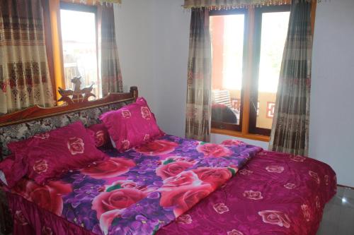 a bedroom with a bed with pink sheets and roses at Ocean holiday in Bira