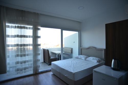 a bedroom with a bed and a large glass window at Yeşilyurt Residence in İzmir