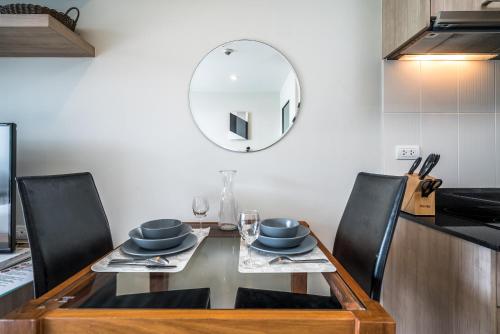 a dining room with a table and a mirror at Apartments at The Bliss Condo by Lofty in Patong Beach