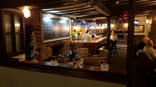 un bar con chimenea y gente sentada en un bar en The Wheatsheaf Inn en Ludlow