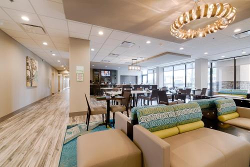 a restaurant with couches and tables and a dining room at Holiday Inn Knoxville N - Merchant Drive by IHG in Knoxville