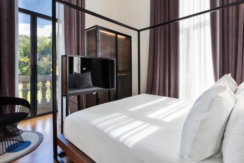 a bedroom with a bed with a tv and a window at One Shot Tabakalera House in Donostia-San Sebastián