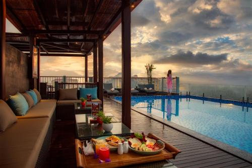 a resort with a pool and a table with a tray of food at Cozy Savvy Boutique Hotel Hoi An in Hoi An