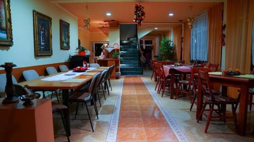a dining room with tables and chairs in a restaurant at Motel Ioanis in Mîndruloc