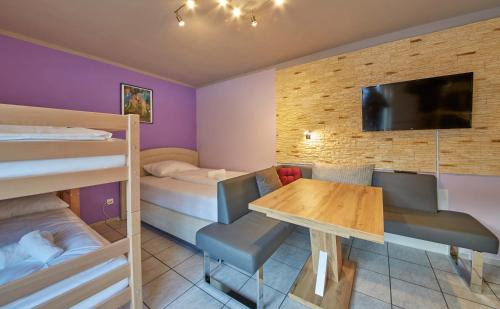 a room with bunk beds and a table and a tv at Appartement White Chili in Saalbach Hinterglemm