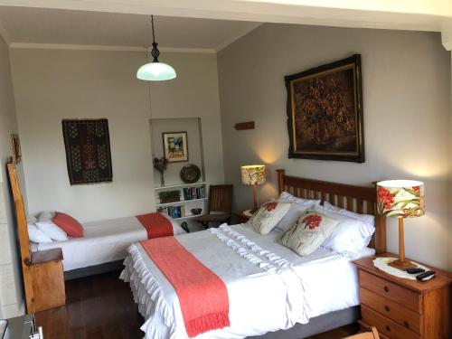 a bedroom with two beds and two lamps at Baylight Accomodation in Mossel Bay