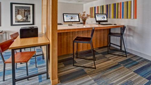 a bar in a room with two chairs and a desk at Murfreesboro Central Hotel in Murfreesboro