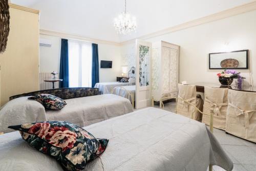 a hotel room with two beds and a table at Santa Caterina da Siena B&B in Catania