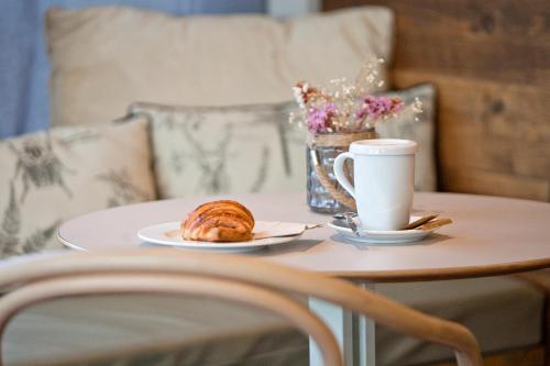 a table with a plate of food and a cup of coffee at Arrels d'Emporda in Palafrugell