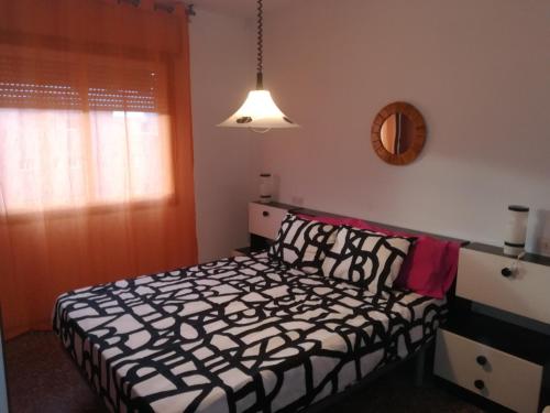 リョレート・デ・マルにあるApartamento El Vilatgeのベッドルーム1室(ベッド1台、壁掛け鏡付)