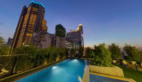 a swimming pool in a city with tall buildings at Y2 Residence Hotel Managed by HII in Manila