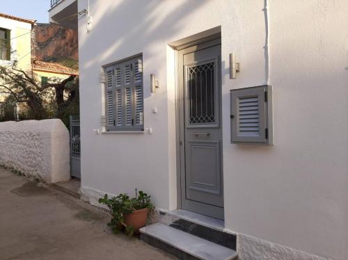 a white building with a blue door and windows at Garden's Home 2 in Leonidion