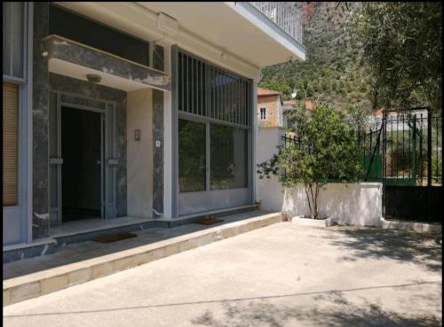 a house with a front porch with a door at Garden's Home 2 in Leonidion