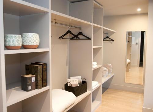 a walk in closet with white shelves and a mirror at Arrels d'Emporda in Palafrugell