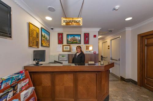 a woman standing at a reception desk in a store at Aristocrat Hotel in Istanbul
