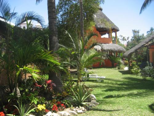 a garden in front of a house with plants at Unelma Bungalows in Bucerías