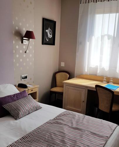 a hotel room with a bed and a desk and a desk at Hotel de Champagne in Épernay