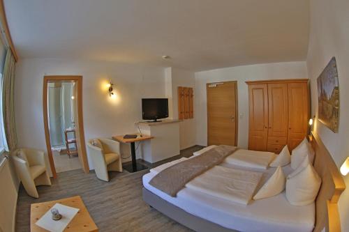 a hotel room with a large bed and a desk at Frankenhof in Scharnitz