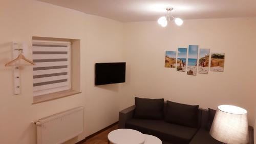 a living room with a couch and a window at Ferienwohnung Smillenzweg mit Garten in Lohme