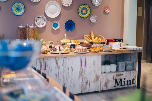 a buffet of food on a table with plates on the wall at Garni Hotel Mint in Belgrade