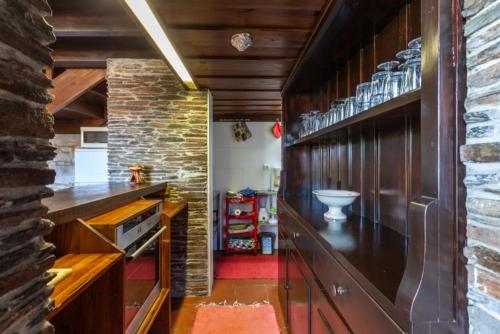 a kitchen with wooden cabinets and a brick wall at Quinta S. Romao do Neiva in Castelo do Neiva