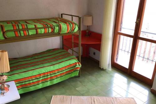 1 dormitorio con literas, mesa y ventana en Appartamento Residence nel Parco, en Camigliatello Silano