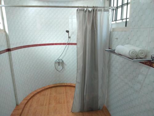 a shower with a shower curtain in a bathroom at Rainforest Munnar in Munnar